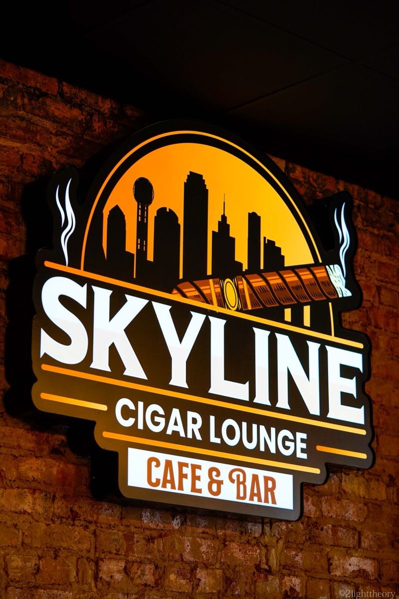 The Skyline Cigar Lounge sign in neon on a brick wall